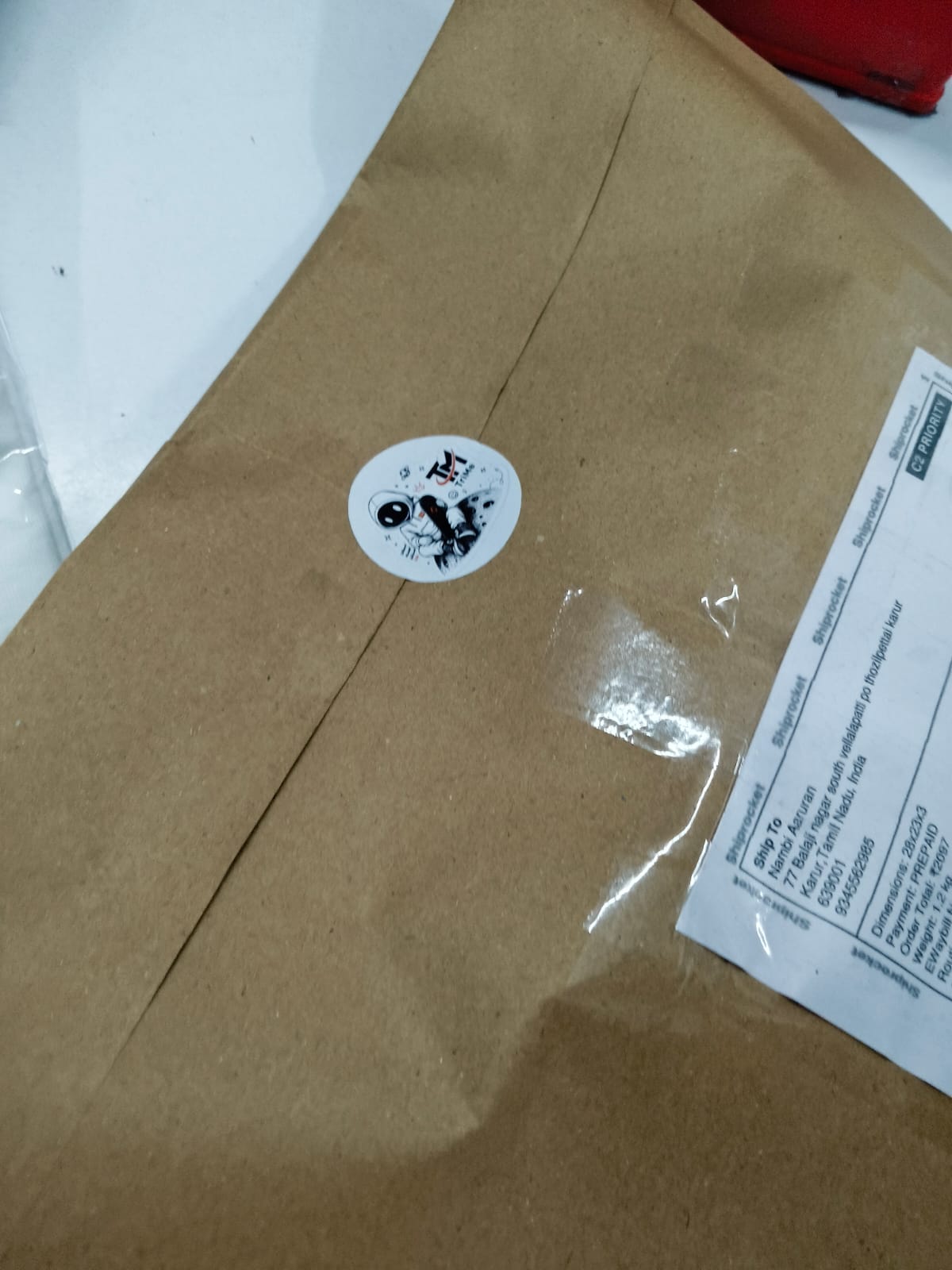 Kraft mailer sealed with TRI/ME sticker and Shiprocket prepaid shipping label