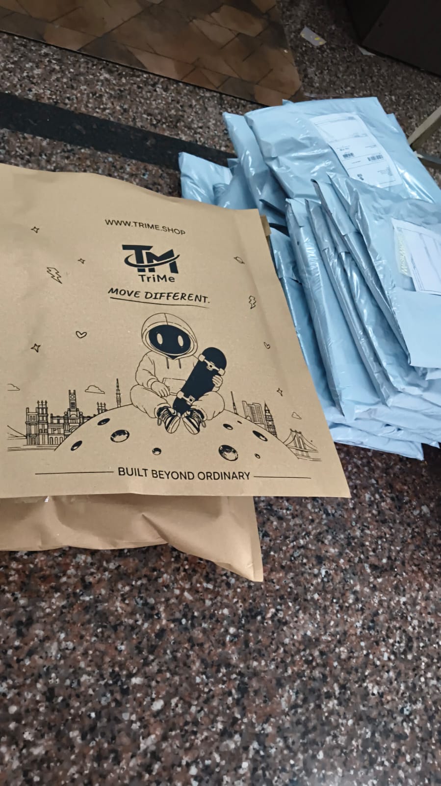 TRI/ME branded kraft mailer with astronaut artwork